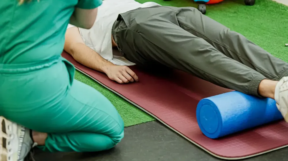 Fisioterapeuta trabajando con un paciente en colchoneta